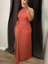 Woman wearing a rust-colored sleeveless maxi dress with a high slit, showing the full length of the dress.