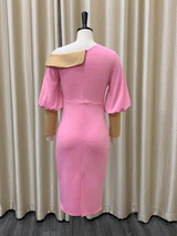 back view of pink sheath dress with asymmetrical neckline and balloon sleeves displayed on a mannequin