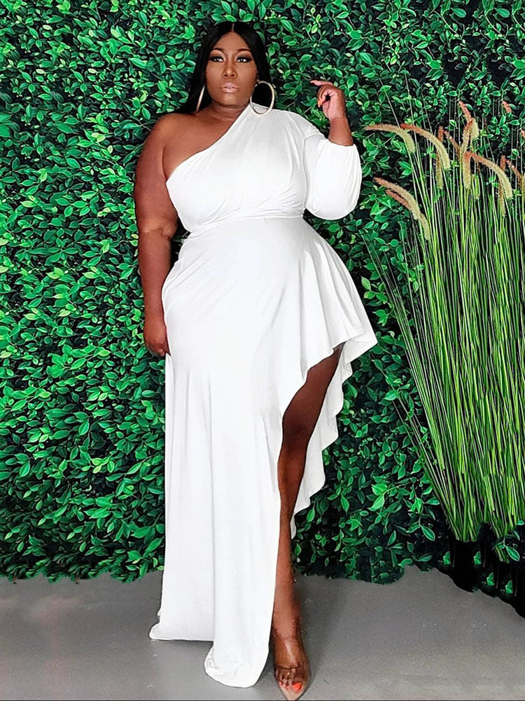 Woman wearing a white one-shoulder maxi dress with an asymmetrical hemline and ruffle detail.