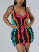 Front view of a woman in a black sleeveless mini dress adorned with multicolored ruffles, hands on hips.