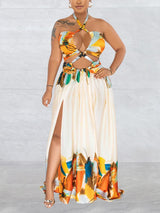 woman wearing a cream colored abstract print halter neck maxi dress with cut-out details and a high slit showing her leg