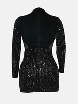 Back view of a black sequined mini dress with velvet bodice and long sleeves.