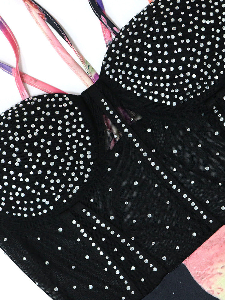 Close-up of the sparkling rhinestone embellishments on the black mesh bodice of a dress