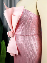 close-up of the pink sequined strapless column dress with a large pink bow detail on the bodice