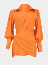 orange wrap dress displayed on a hanger