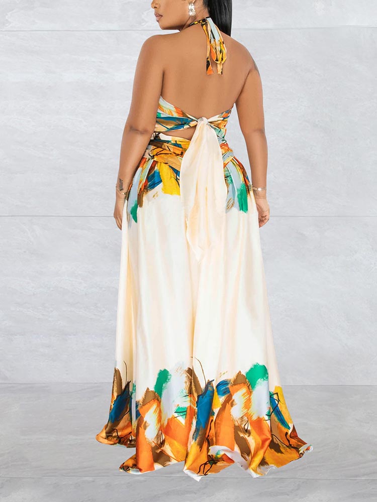 back view of a woman wearing a cream colored abstract print halter neck maxi dress with cut-out details