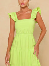 Close-up of the square neckline and flutter sleeves of a lime green maxi dress.