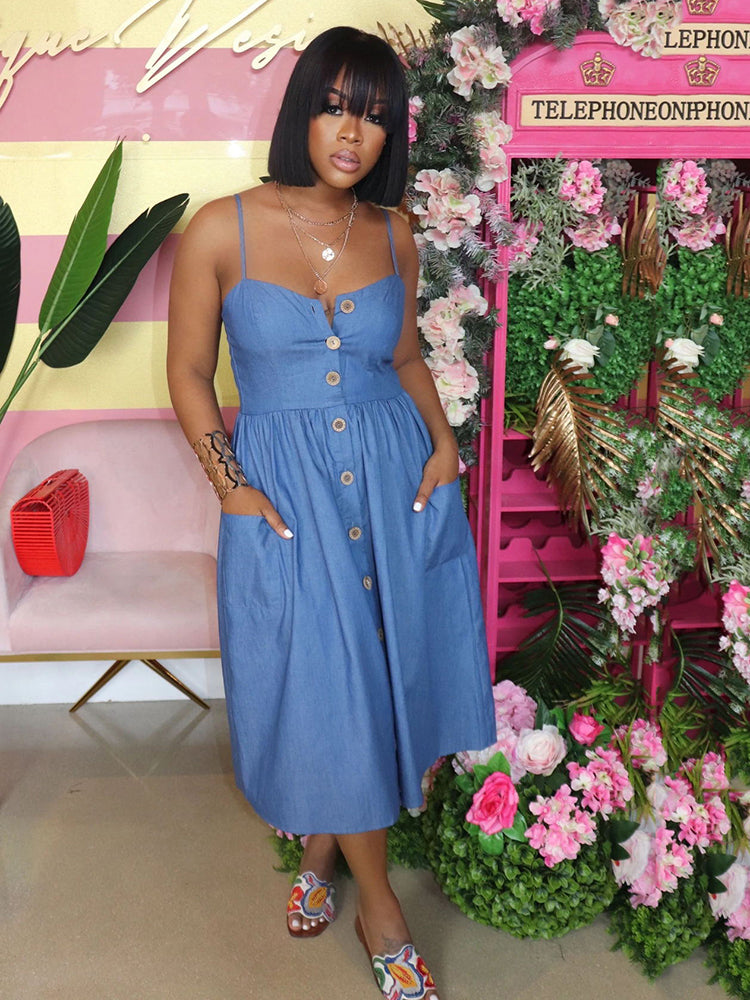 woman in a blue denim midi dress with spaghetti straps and a button-down front