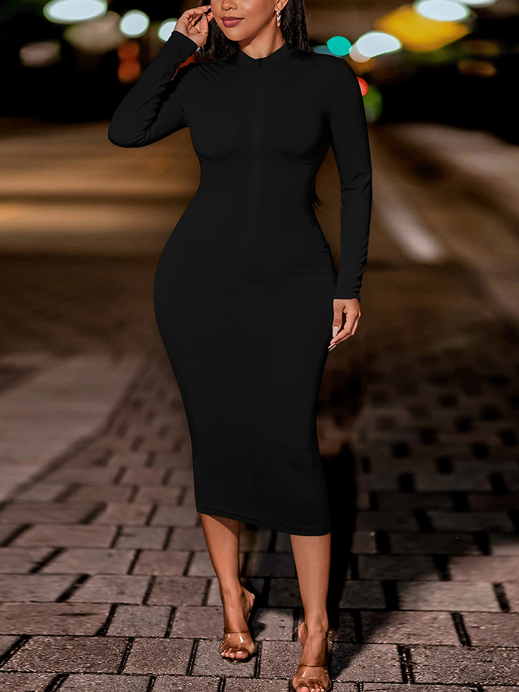 Woman in a black fitted midi dress with long sleeves and a zip-up neckline, posing outdoors.