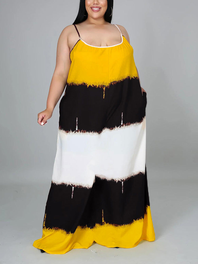 Woman wearing a yellow, black, and white tie-dye maxi dress with spaghetti straps and pockets, front view.