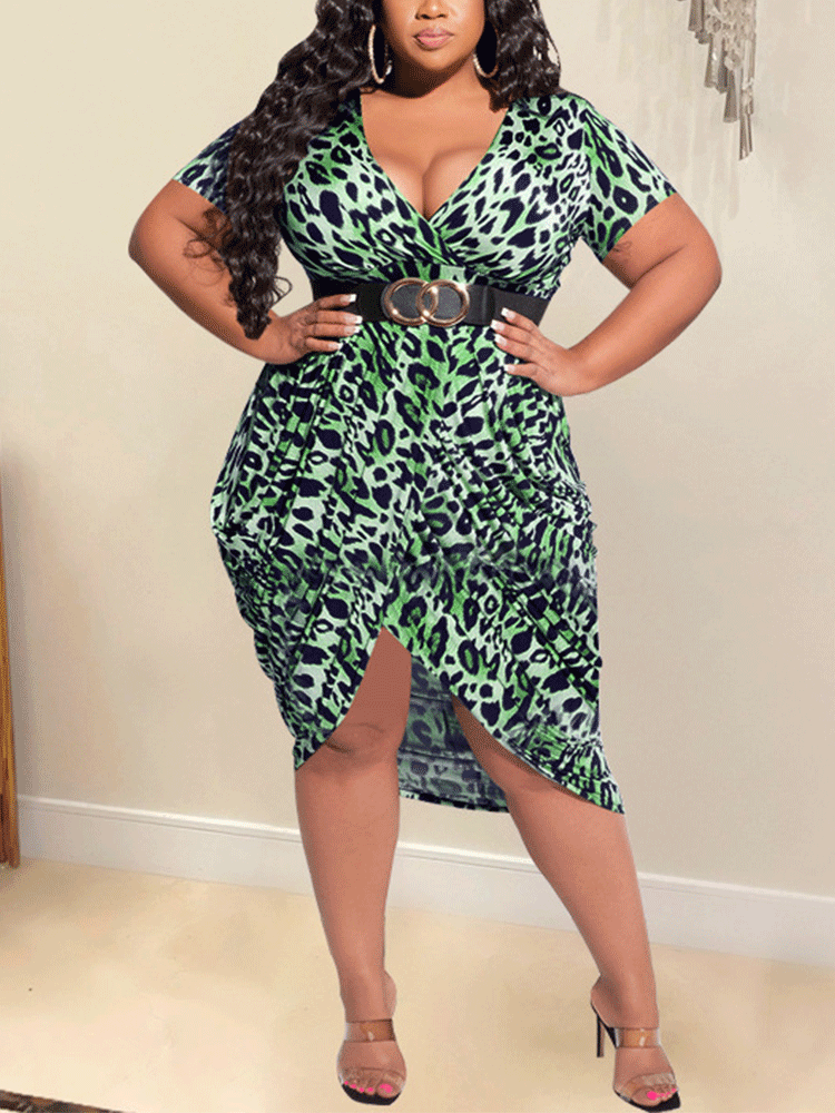 Plus-size woman wearing a green leopard print V-neck dress with short sleeves, an asymmetrical hem, and a belt.