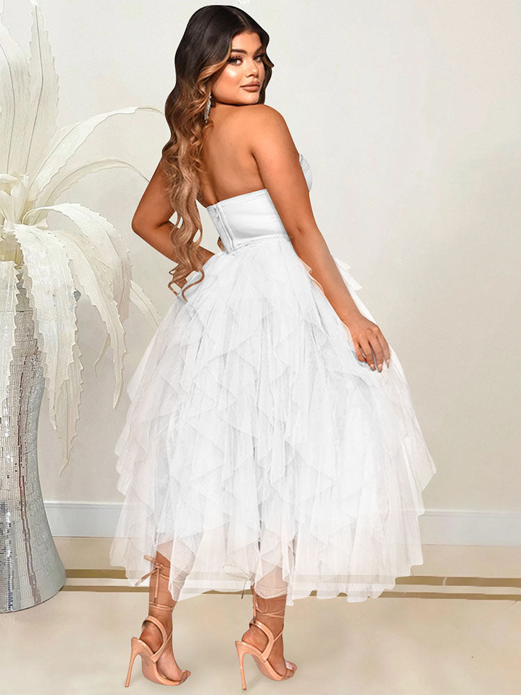 Rear view of a woman in a white strapless formal dress with a sweetheart neckline and a tiered tulle skirt.