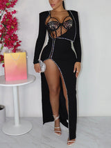 Woman posing in a black floor-length dress with a dramatic high slit and delicate embellishments.