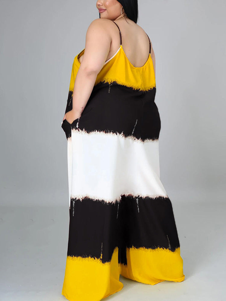Woman wearing a yellow, black, and white tie-dye maxi dress with spaghetti straps and pockets, back view.