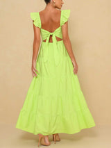 Woman wearing a lime green tiered maxi dress with flutter sleeves and a square neckline, back view showing tie closure.