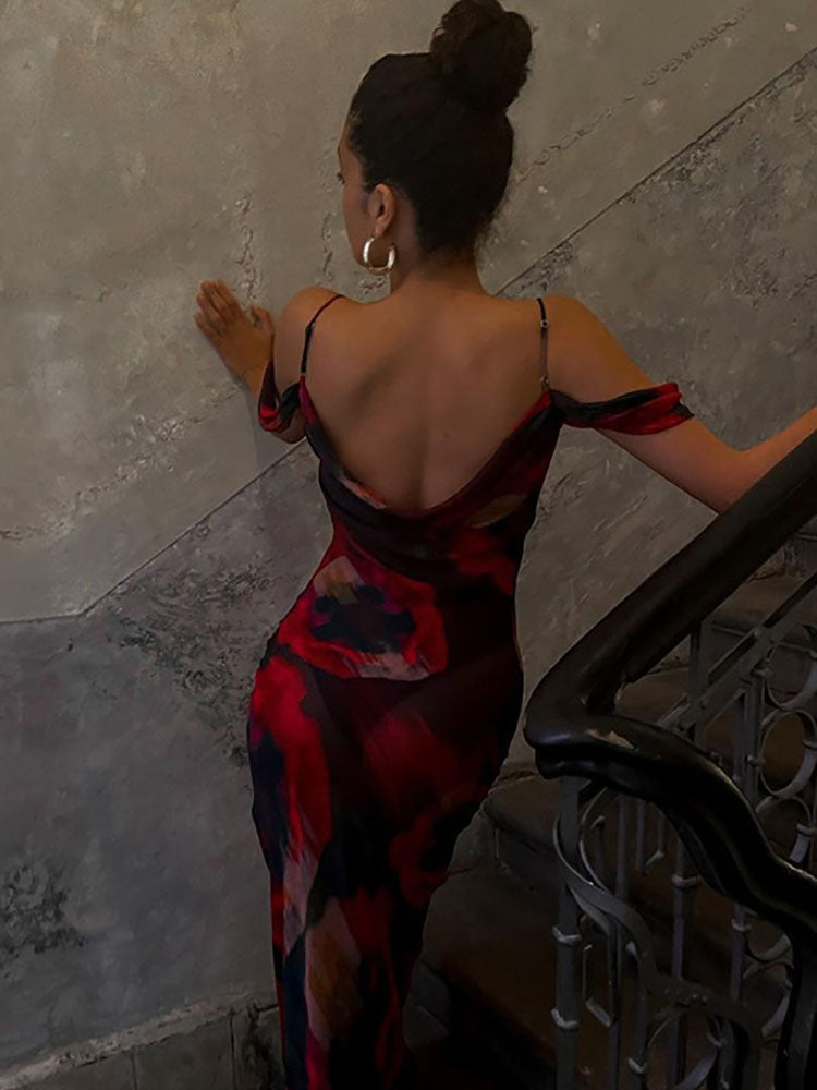 Woman wearing a backless abstract floral print maxi dress with cold shoulder sleeves on a staircase.