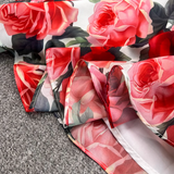 Close-up of the hem and slit of the floral print dress, revealing the lightweight fabric.