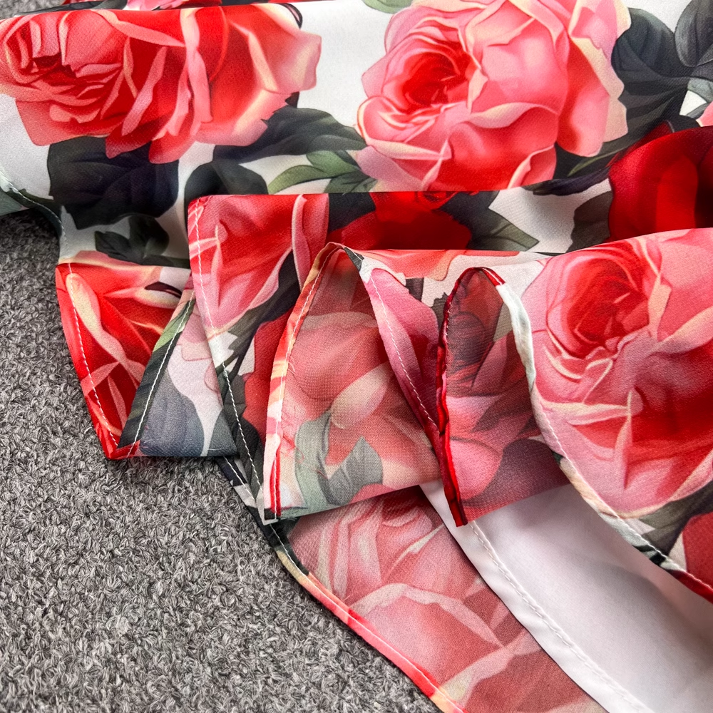 Close-up of the hem and slit of the floral print dress, revealing the lightweight fabric.