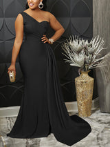 Woman wearing a black one-shoulder formal gown with a thigh-high slit and mermaid hemline, holding a clutch.