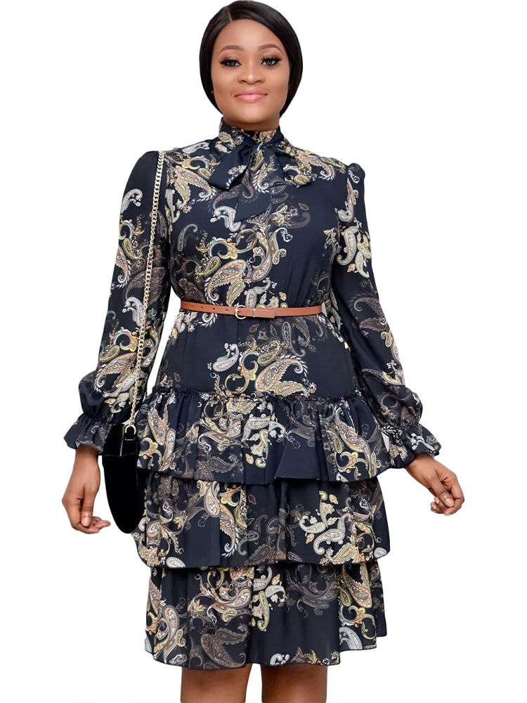 Woman wearing a black tiered ruffle dress with paisley print, brown belt, and black handbag.