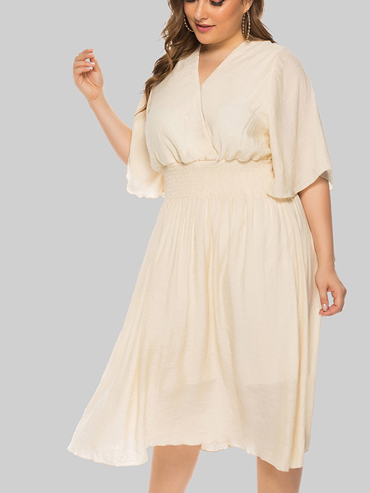 Plus-size woman wearing a cream midi dress with flutter sleeves and a smocked waist, shown from the front-side.