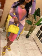 Woman wearing a long-sleeved, midi-length bodycon dress with a colorful geometric print, paired with yellow strappy heels and a yellow handbag.