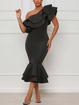 Woman wearing a black one-shoulder midi dress with ruffle details and a mermaid hem.