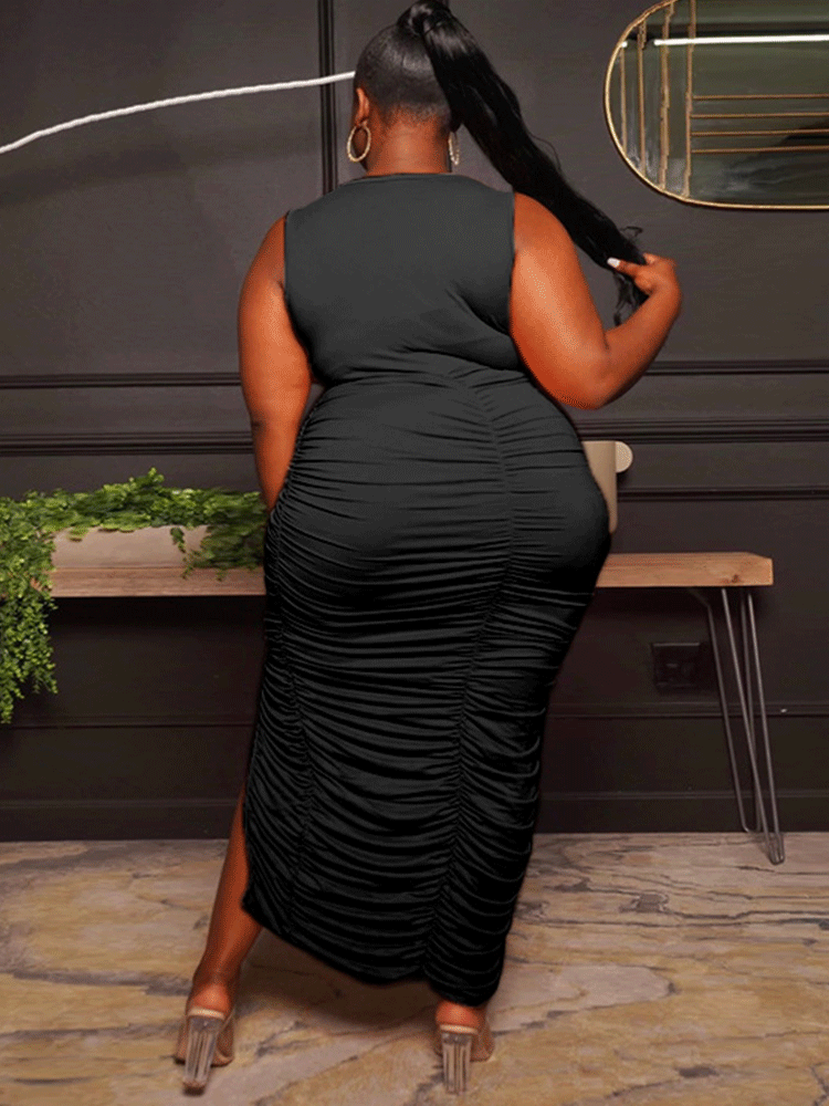 back view of a woman wearing a black ruched midi dress with a square neckline and high slit