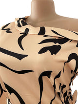 Close-up of the neckline and print on the peach and black abstract print sheath dress.