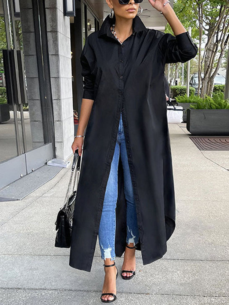 Woman wearing a long black button-down shirt dress with blue jeans and black high heels