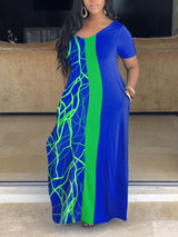 Woman wearing a blue and green color block maxi dress with an abstract graphic print.