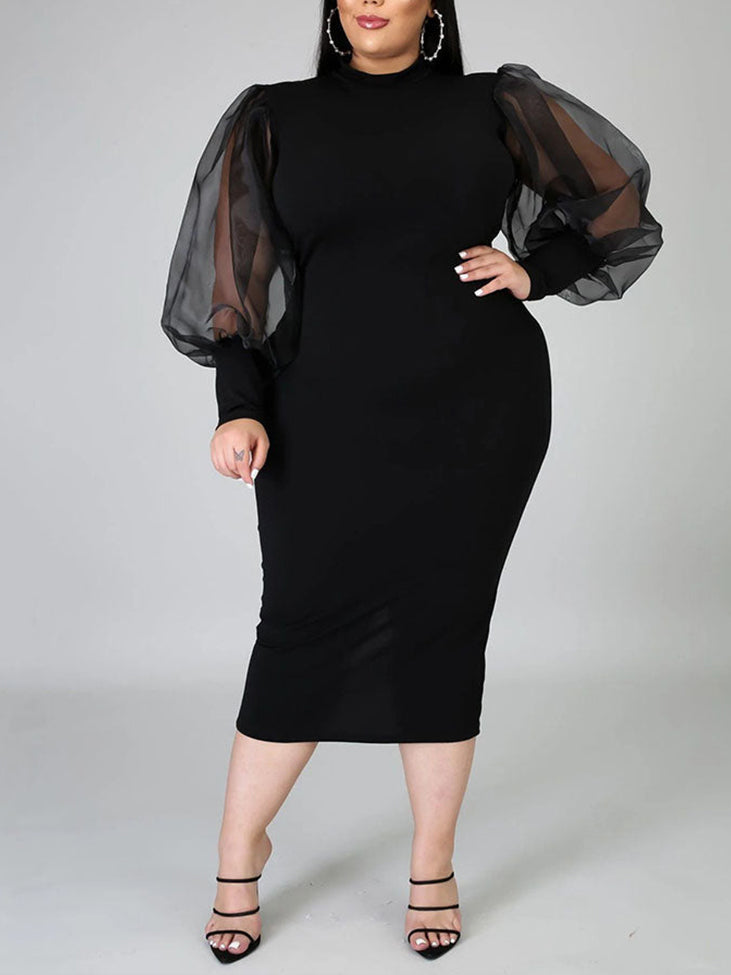 Plus-size woman wearing a black mock neck sheath dress with sheer puff sleeves and a slit hem, front view