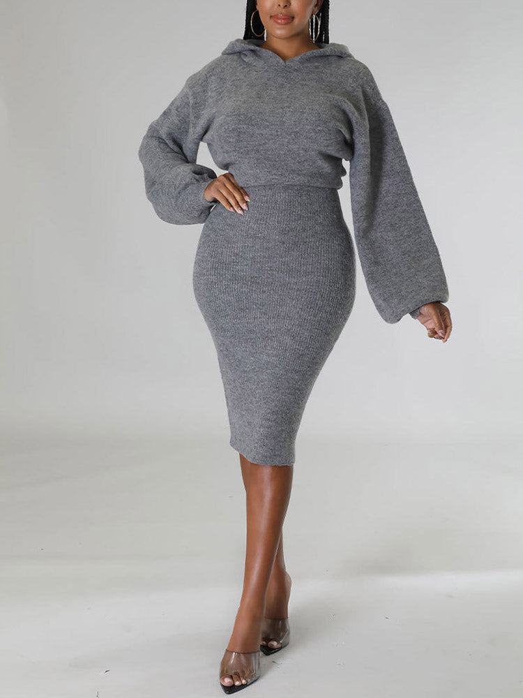 Woman wearing a grey hooded knit sweater and pencil skirt set, front view.