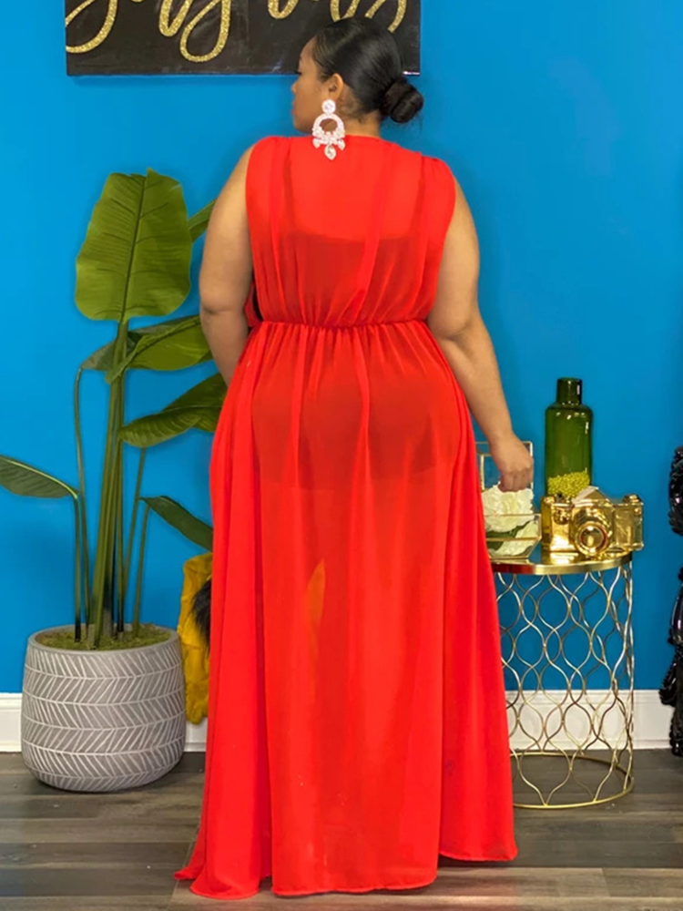Woman wearing a red sheer maxi dress with high leg slits, back view