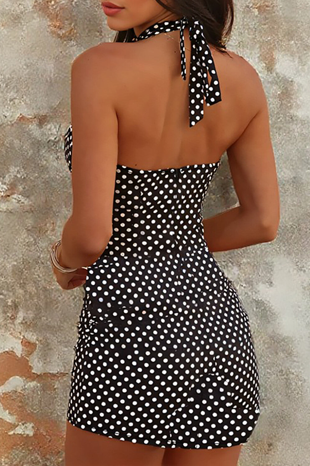 back view of woman in polka dot halter swimsuit