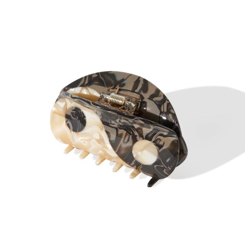 Top-down view of a Yin Yang hair claw clip showing the clasp mechanism