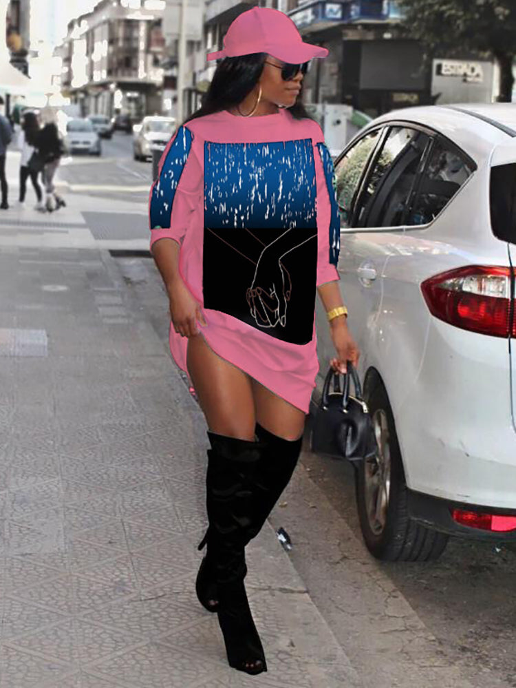 Woman wearing a pink graphic print dress with black boots and a pink cap