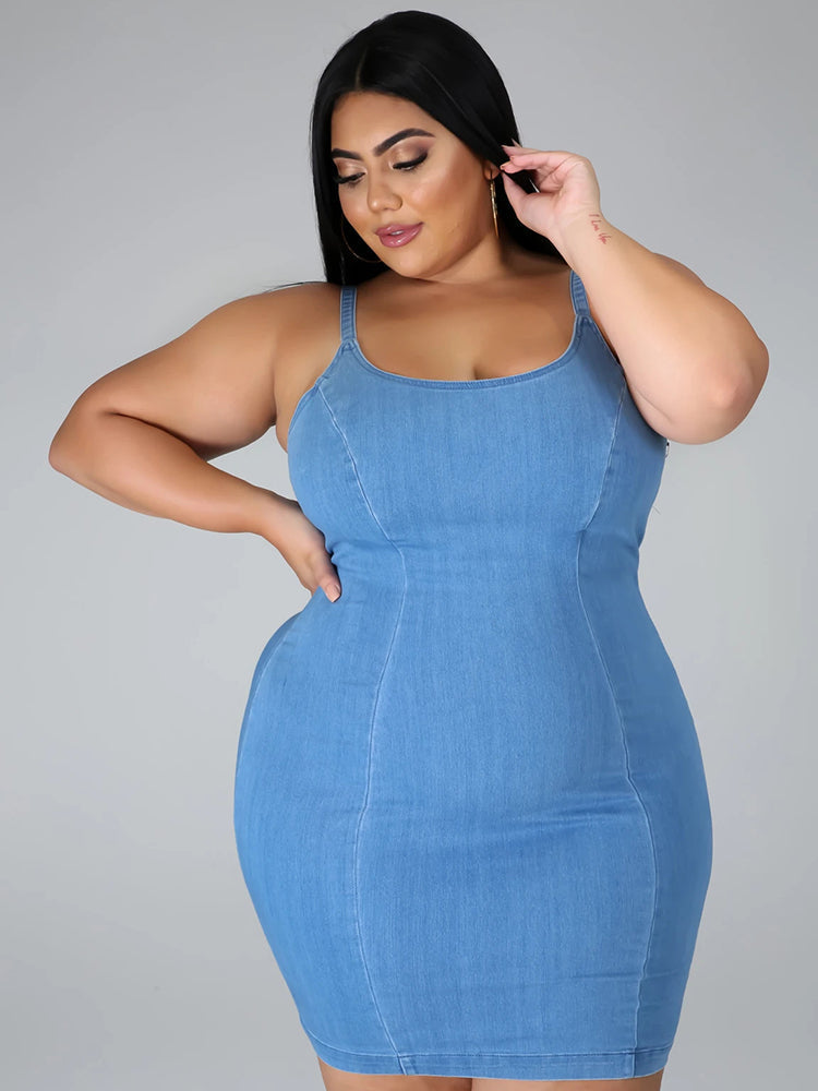 Woman wearing a denim sheath dress with spaghetti straps and a scoop neckline.