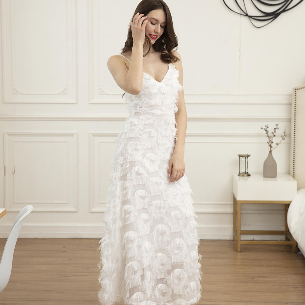 Woman wearing a white feather-trimmed midi dress with spaghetti straps and a v-neck, posing indoors.