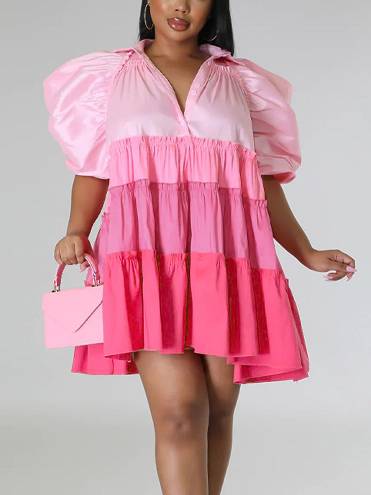 Woman wearing a pink tiered mini dress with puff sleeves and a v-neck