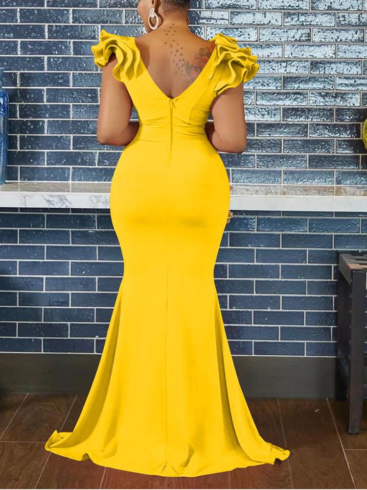 Back view of a woman in a yellow mermaid-style formal gown, showcasing the zipper and ruffled sleeves.