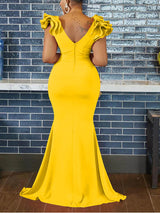 Back view of a woman in a yellow mermaid-style formal gown, showcasing the zipper and ruffled sleeves.
