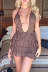 Woman wearing a brown tiered ruffle mini dress with a deep V-neck and halter straps.