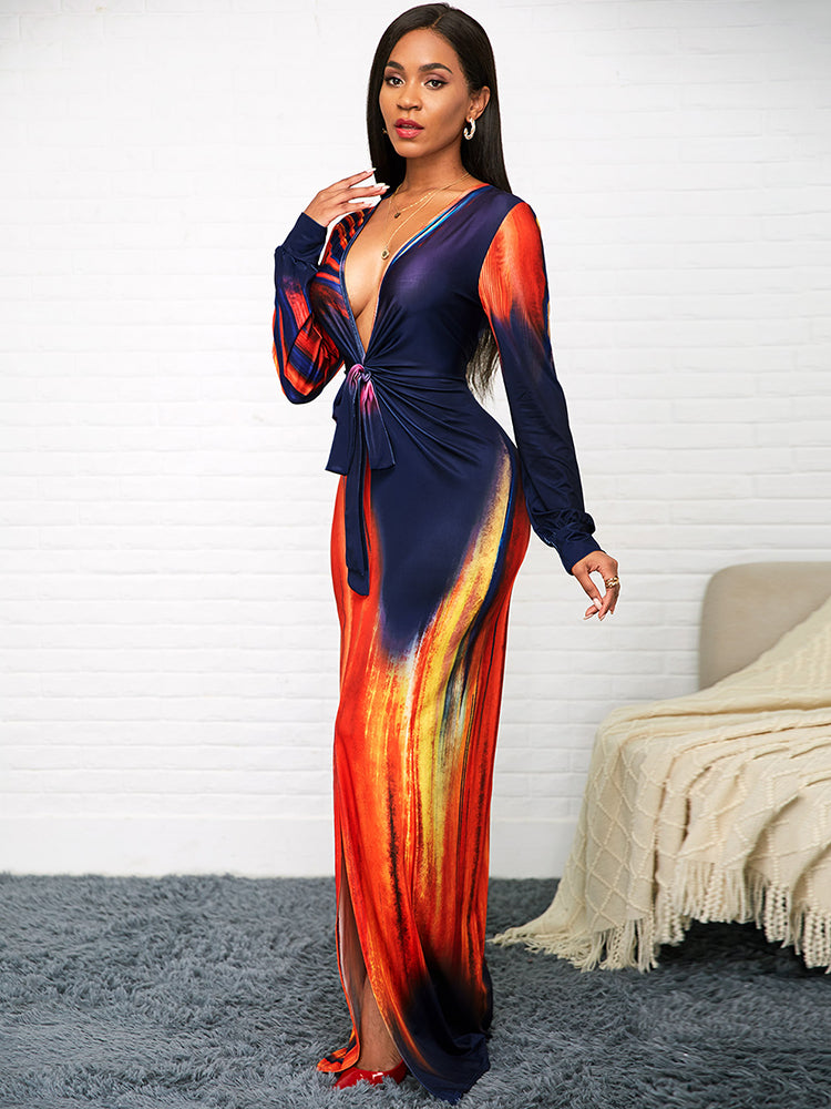 Side view of a woman wearing a long, fitted dress with a deep V-neck and high slit.