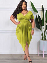 Back view of a plus-size model wearing a lime green ruched V-neck short-sleeve dress with a tulip hem.