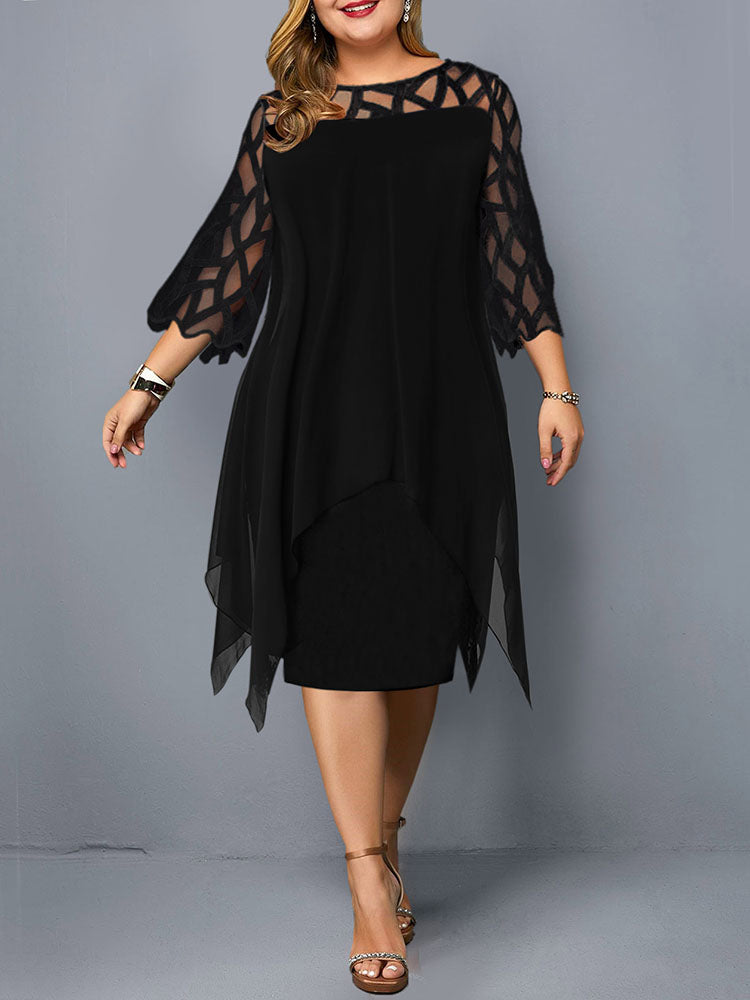 Plus-size woman wearing a black layered dress with geometric mesh sleeves and an asymmetrical hemline, standing against a grey background.