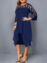 Side view of a plus-size woman wearing a navy blue layered dress with geometric mesh sleeves and an asymmetrical hemline.