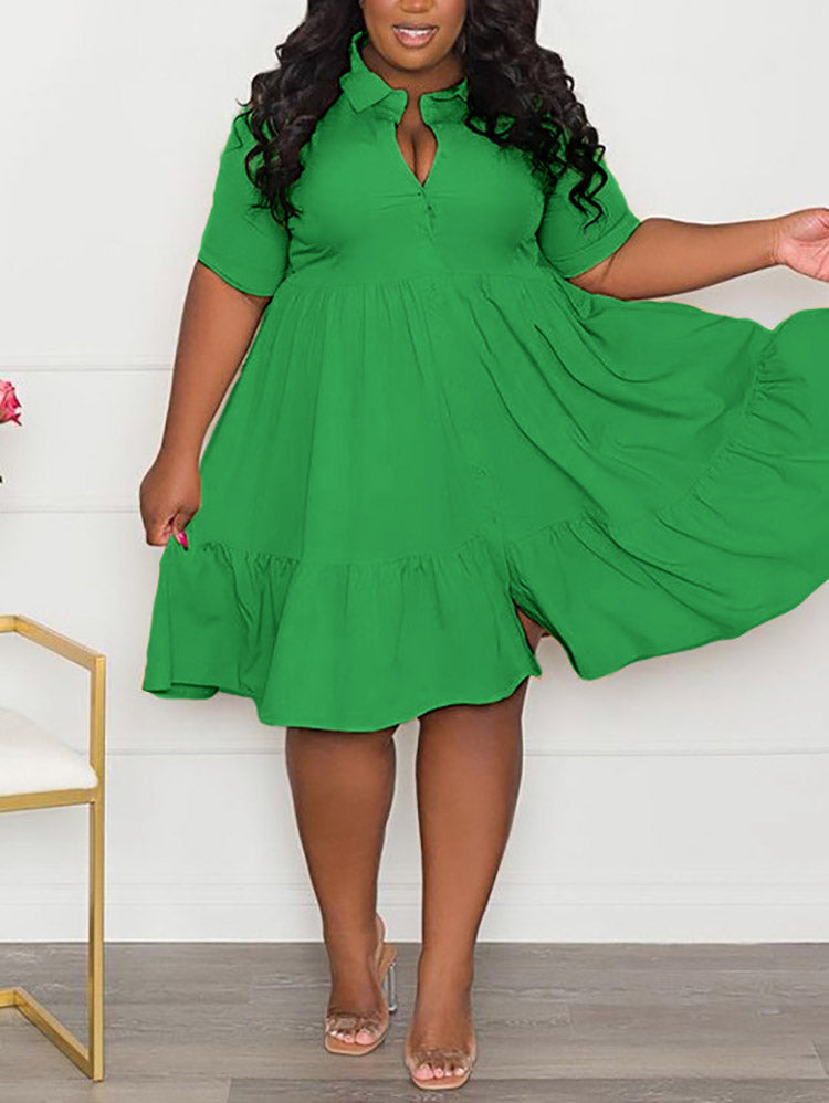 Woman in a green tiered dress, with one hand on her hip, showing the flow of the skirt.