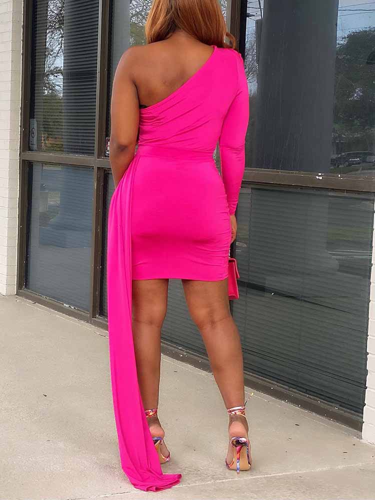 back view of a woman in a hot pink one-shoulder mini dress with a long draped train