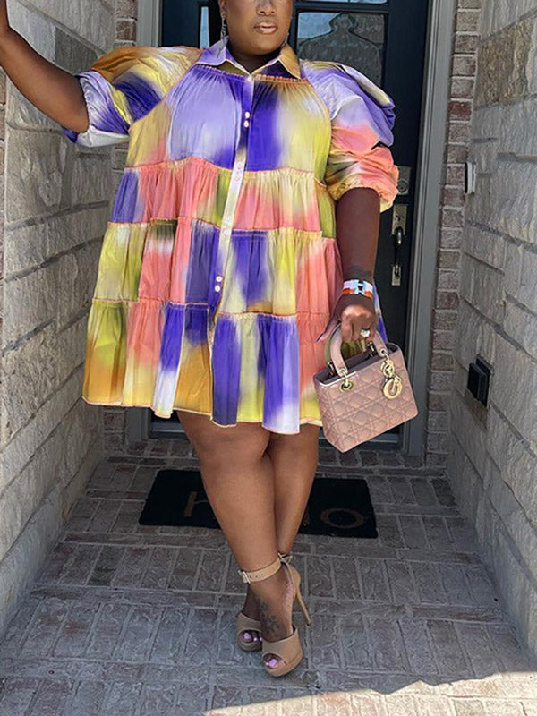 Woman in a multi-colored tie-dye tiered dress with a collared neckline and puff sleeves